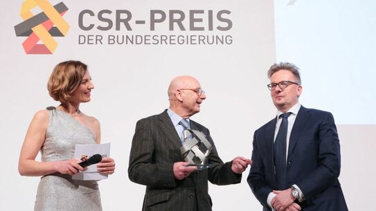 Prof Josef Wieland at the CSR Award ceremony with Michael Rauterkus, CEO of Grohe AG (right), and moderator Tanja Samrotzki (Source: Tom Maelsa / BMAS).