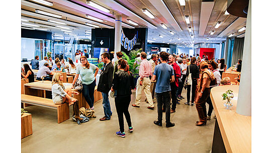 Menschen verteilt in der vollen Mensa der Uni